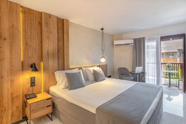 Schlafzimmer im Ikaros Beach Luxury Resort & Spa mit Bett, Nachttisch und Klimaanlage
