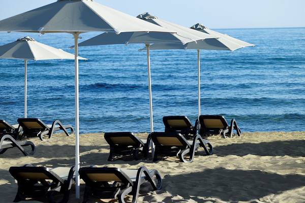 Strand mit Sonnenliegen und Sonnenschirmen am Ikaros Beach Luxury Resort & Spa