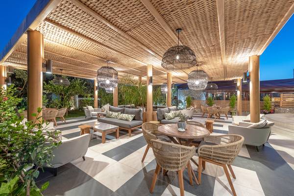 Außenbereich des Ikaros Beach Luxury Resort & Spa mit beleuchteten Möbeln und Pflanzen