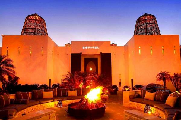 Außenbereich des Sofitel Agadir Royal Bay Resorts mit einem großen Feuerstellen und zwei Sofas