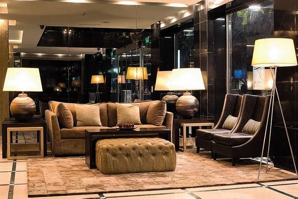 Hotellobby mit einem großen Sofa, Lampen und einem Teppich auf dem Boden.