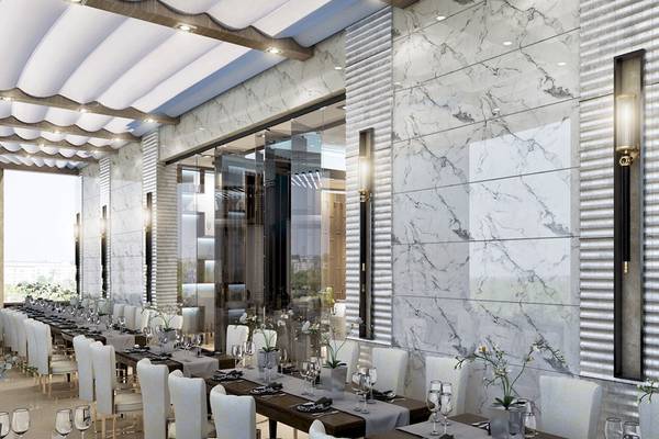 Innenansicht des Restaurants im Belad Bont Resort mit Marmorwänden und langen Tischen.