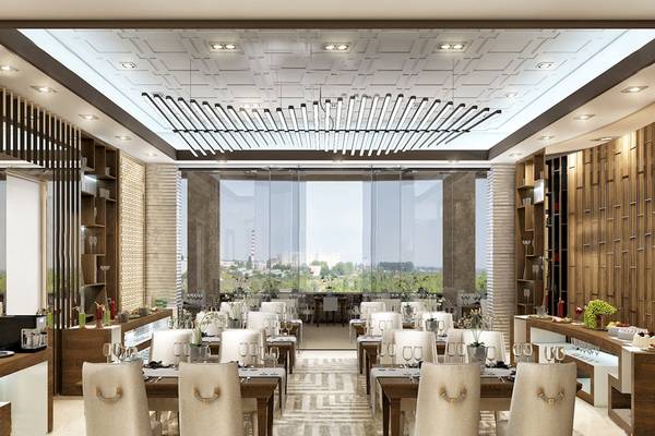 Innenansicht des Restaurants im Belad Bont Resort mit runden Tischen, Stühlen und großen Glaswänden.