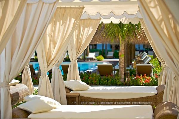 Zwei Loungebetten unter einem Baldachin am Pool des Iberostar Grand Rose Hall