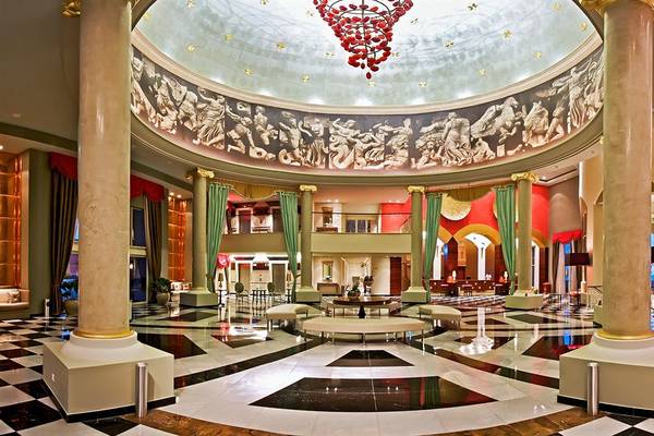 Foyer des Iberostar Grand Rose Hall Hotels mit Säulen und schwarz-weißem Schachbrettboden.