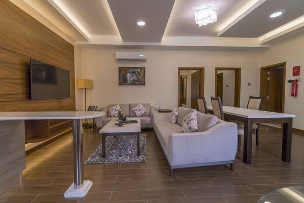 Wohnzimmer im Belad Bont Resort mit Fernseher, Sofas, Tisch und Stühlen.