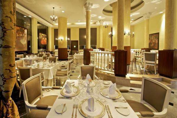 Innenansicht des Restaurants im Iberostar Grand Rose Hall Hotel mit gedeckten Tischen und eleganter Einrichtung.