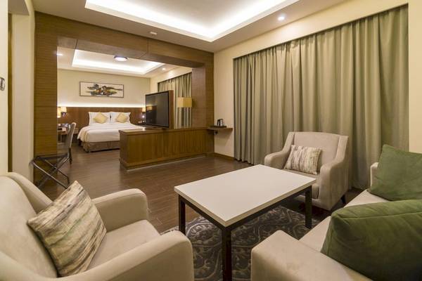 Innenansicht einer Suite im Belad Bont Resort mit Wohnzimmer, Fernseher und Schlafzimmerbereich.