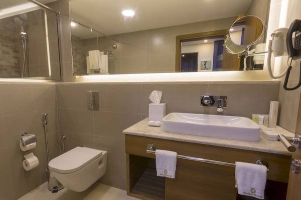 Badezimmer des Belad Bont Resorts mit moderner Ausstattung, einschließlich einer Toilette, eines Waschbeckens und eines Spiegels.