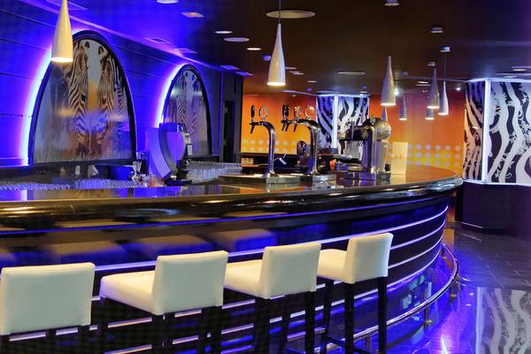 Innenansicht der Bar im Servatur Waikiki Hotel mit moderner Einrichtung und stilvollen Möbeln.