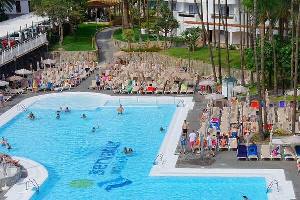 Luftaufnahme des Schwimmbadbereichs des Servatur Waikiki Hotels mit vielen Gästen