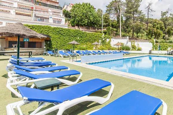 Pool-Loungebereich des Bluesea Callao Garden Hotels mit blauen Sonnenliegen und Sonnenschirmen.