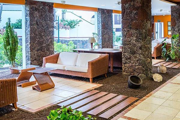 Lobby des BLUESEA Callao Garden Hotels mit Möbeln und Pflanzen.