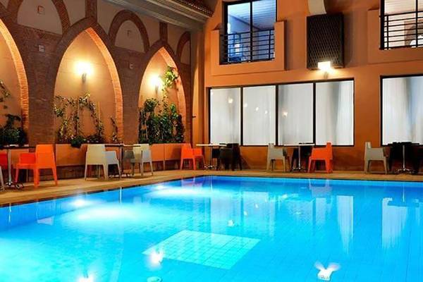 Innenpool des Bluesea Callao Garden Hotels mit bunten Stühlen und Tischen