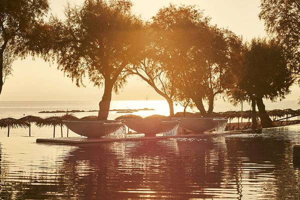 Sonnenuntergang am Pool des Grecotel Casa Marron Hotels mit Wasserfontaenen und Meersicht