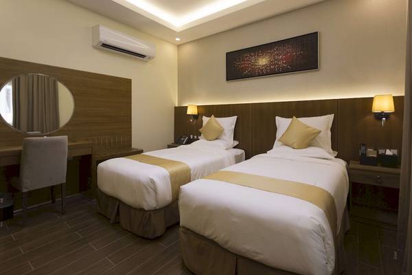 Doppelzimmer im Belad Bont Resort mit zwei Betten, Schreibtisch, Spiegel und Klimaanlage.