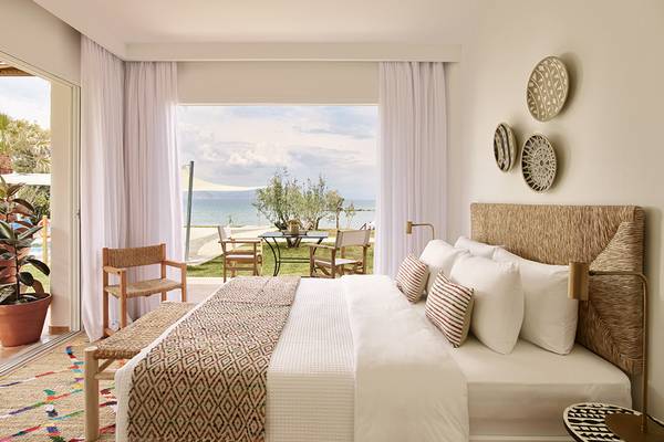 Innenansicht eines Zimmers im Grecotel Casa Marron Hotel mit Blick auf das Meer und eine Terrasse.