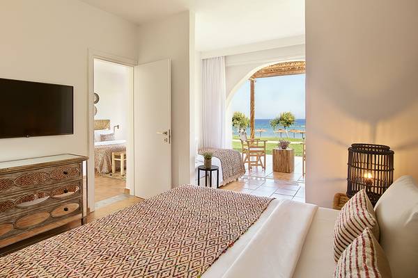 Innenansicht eines Zimmers im Grecotel Casa Marron mit Blick auf das Meer und eine Terrasse.