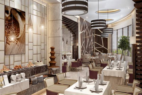 Innenansicht des Belad Bont Resorts Restaurant mit Marmorwänden, modernen Möbeln und mehreren Tischen mit Servietten und Geschirr.