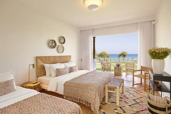 Zimmer im Grecotel Casa Marron mit Meerblick, zwei Betten, Fenstern und Möbeln.