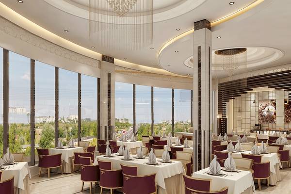 Restaurant im Belad Bont Resort mit Panoramafenstern und Ausblick auf die Stadt.