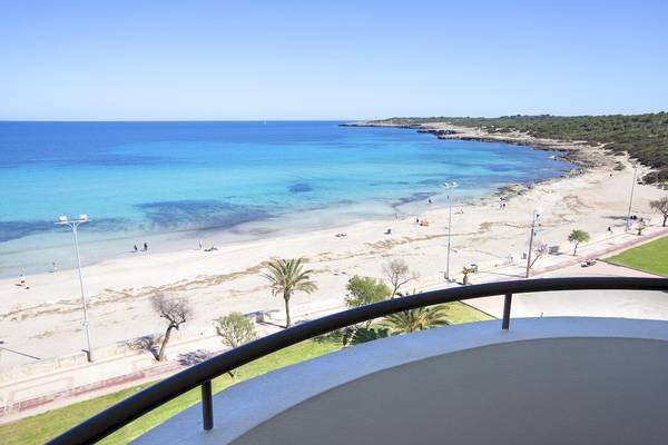 Aussicht auf den Strand vom Hipotels Hipocampo Playa Hotel mit blauem Meer und weißen Sand.