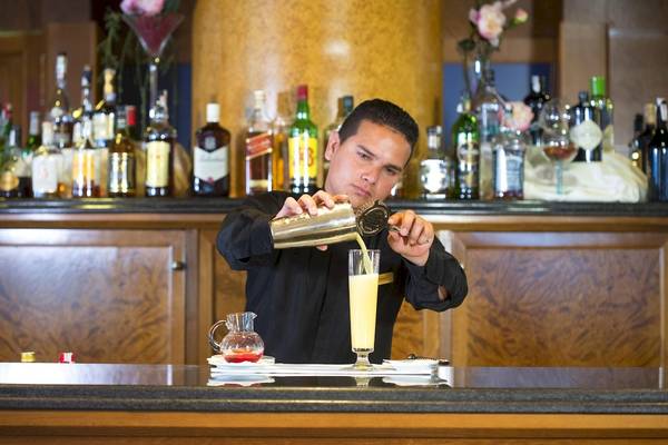 Ein Barkeeper mischt einen Cocktail im Hipotels Hipocampo Playa Hotel.