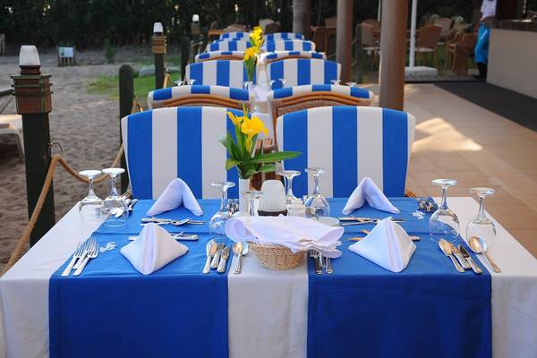 Fame Residence Lara & Spa Esstisch am Strand mit blau-weiß gestreiften Stühlen und Tischdecken.