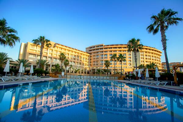 Außenansicht des Fame Residence Lara & Spa Hotels mit großem Swimmingpool und Sonnenliegen