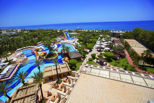 Luftaufnahme des Fame Residence Lara & Spa Hotels mit Pools, Wasserrutschen und Meer im Hintergrund.