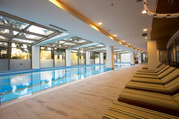 Pool im Fame Residence Lara & Spa Hotel mit Glasdach und Loungebereich