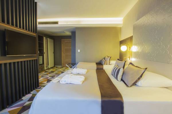Doppelzimmer mit zwei Betten im Fame Residence Lara & Spa Hotel, geräumig mit modernen Möbeln, Fernseher, bequeme Betten und ein Teppichboden.