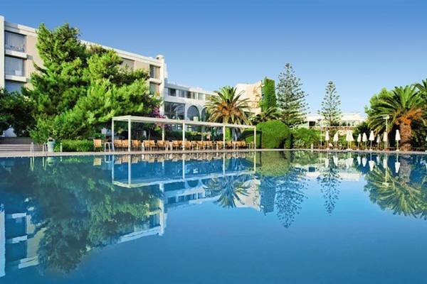 Außenbereich des Caravia Beach Hotel mit Swimmingpool und Sonnenliegen
