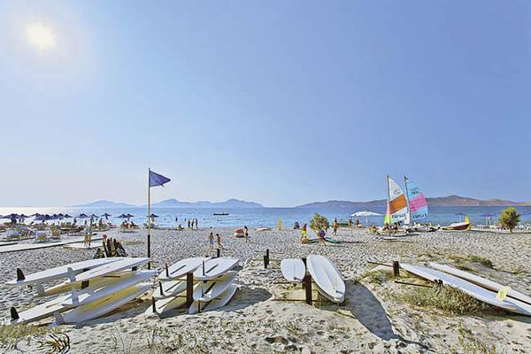 Sonnenuntergang am Strand mit mehreren Segelbooten und Surfbrettern am Caravia Beach Hotel & Bungalows