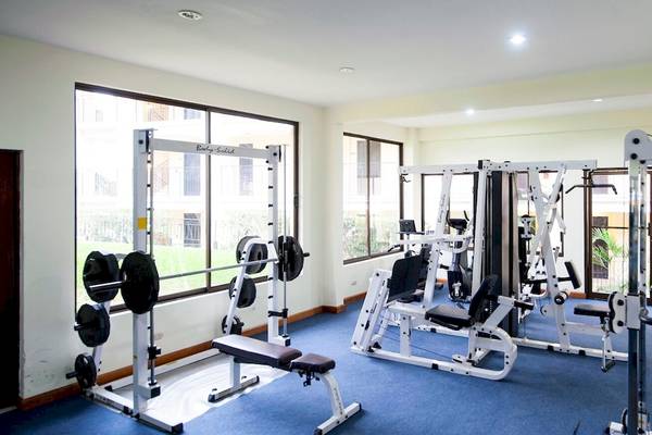 Fitnessraum im Occidental Papagayo Hotel mit verschiedenen Trainingsgeräten und großen Fenstern.