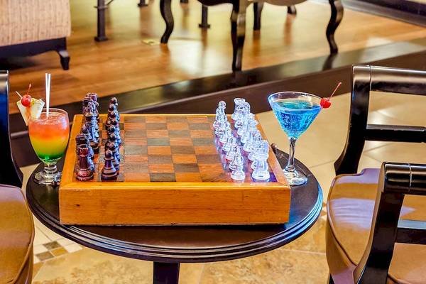 Ein holzner Tisch mit einem Schachbrett und zwei Cocktails auf dem Occidental Papagayo Hotel.