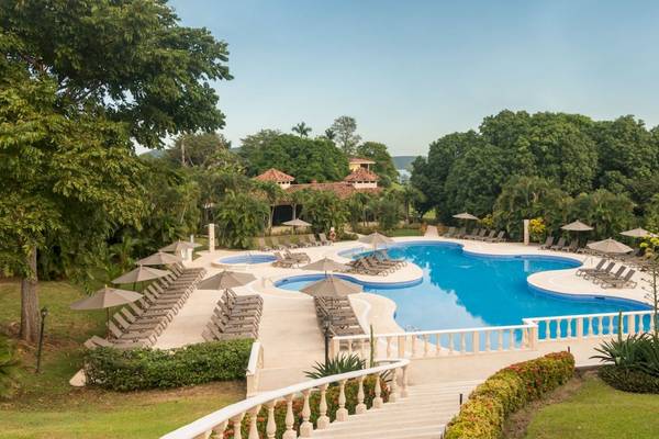 Luftaufnahme des Poolbereichs des Occidental Papagayo Resorts mit Sonnenliegen und Sonnenschirmen.