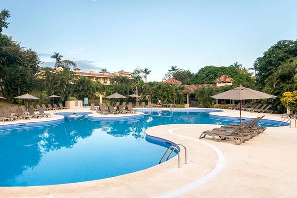 Außenpool des Occidental Papagayo Hotels mit vielen Liegestühlen und Sonnenschirmen