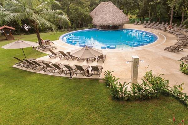 Oberirdischer Swimmingpool mit Lounge-Bereich und Sonnenschirmen im Occidental Papagayo Hotel.