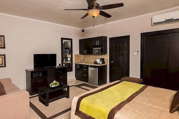 Suite im Occidental Papagayo Hotel mit Fernseher, Couch, Tisch, Klimaanlage und Küche
