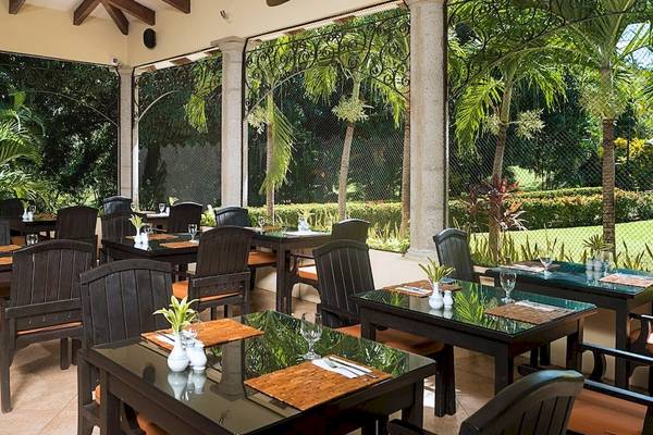Innenansicht des Restaurants im Occidental Papagayo Hotel mit Tischen und Stühlen im Freien.
