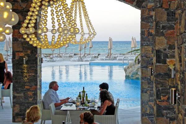 Gäste am Tisch neben dem Pool im The Island Hotel - Kreta