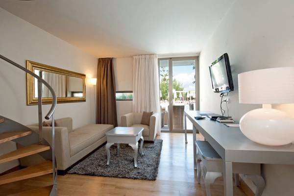 Innenbereich des Island Hotels auf Kreta mit moderner Einrichtung, Sofa, Tisch, Fernseher und Lampe.