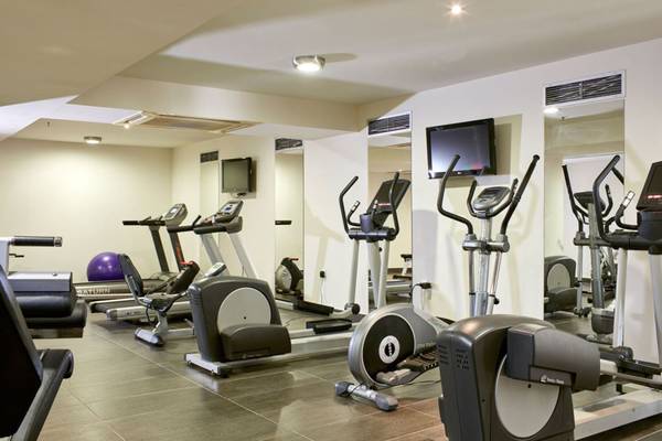 Fitnessstudio im Island Hotel auf Kreta mit verschiedenen Trainingsgeräten und Spiegeln.