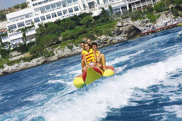Gäste des KoruMar Hotel De Luxe fahren auf einem Bananenboot im Wasser.