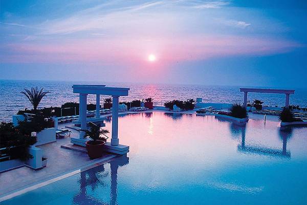 Pool des KoruMar Hotel De Luxe bei Sonnenuntergang mit Blick auf das Meer