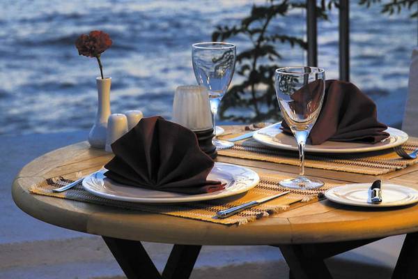 Tisch im Freien mit Abendessen dekoriert, Blick auf das Meer