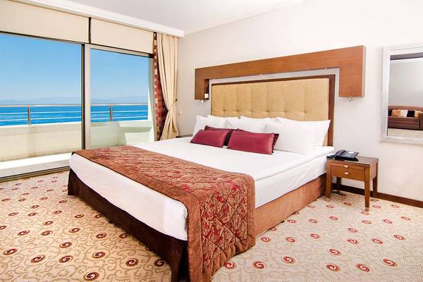 Zimmer mit Meerblick im KoruMar Hotel De Luxe mit einem großen Bett, Aussicht auf das Meer und einem Balkon.