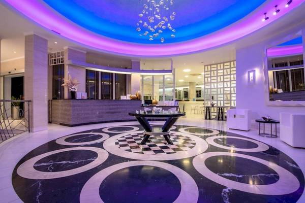 Empfangsbereich des La Mer Deluxe Hotel & Spa mit blauer und lila Beleuchtung und einem zentralen Tisch.