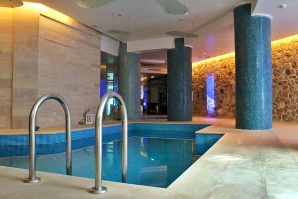 Innenpool des La Mer Deluxe Hotel & Spa mit blauen Fliesen und blauen Säulen.